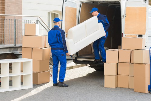 Moving team carrying furniture through a narrow stairwell