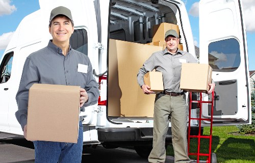Removal team handling packed boxes and furniture for a house move